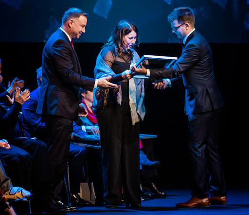 Zdjęcie Prezydenta RP Andrzeja Dudy oraz Dominiki Madaj-Solberg, prezes Fundacji SPINA, a także prowadzącego galę wręczenia nagród „Dla Dobra Wspólnego”.