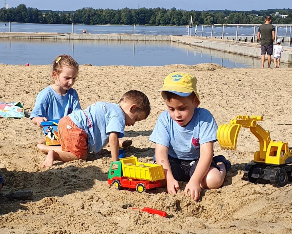 Podopieczni Fundacji SPINA bawiący się na plaży w Łące.